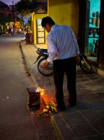Shopkeeper burning offerings at the end of the day